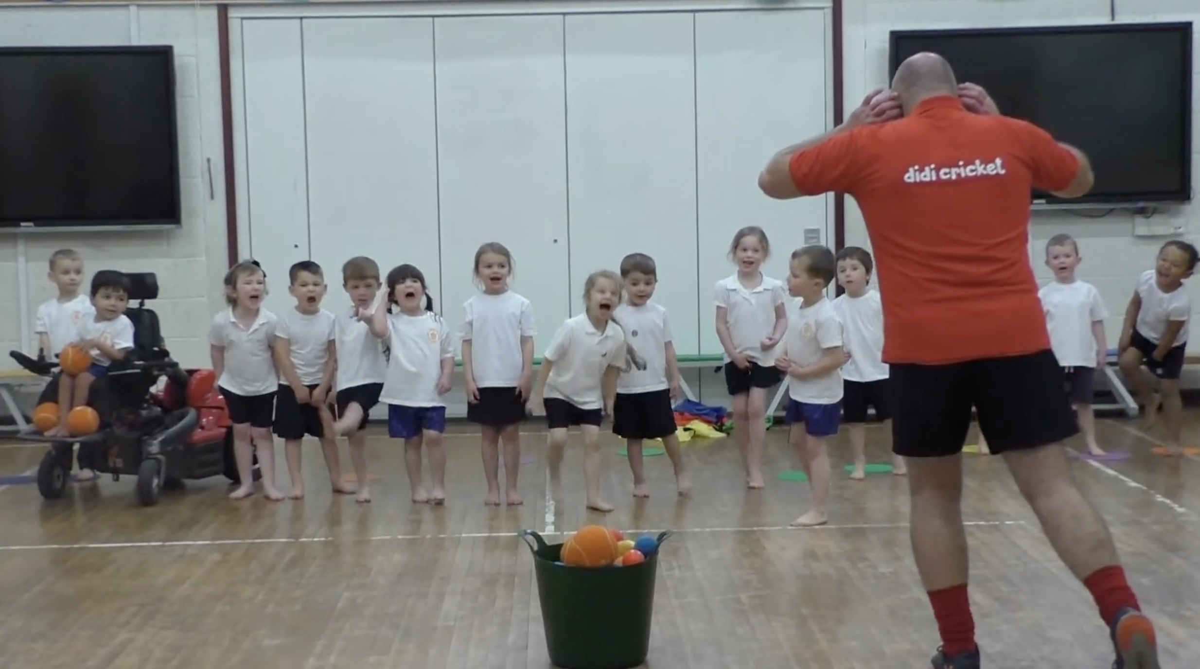 didi cricket coach Keith Smith has fun with a class of children in a sports hall