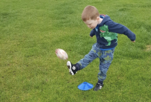 Zachary kicks the ball at a didi rugby session at Birstall Rugby Club