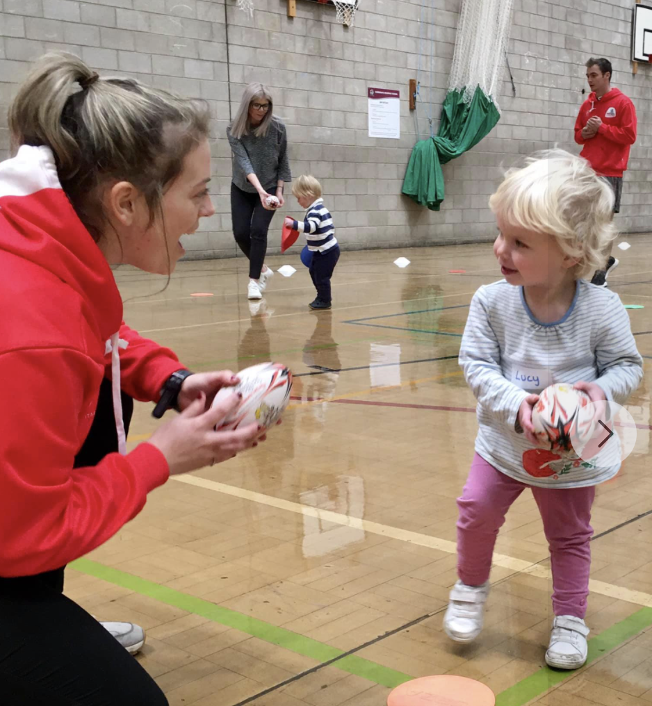 A coach and child have fun at a didi rugby class