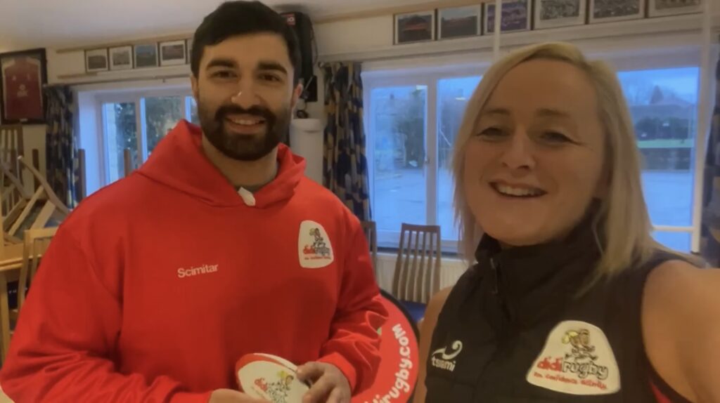 Wearing didi rugby tops, Vicky Macqueen and James O'Ryan smiling towards the camera.