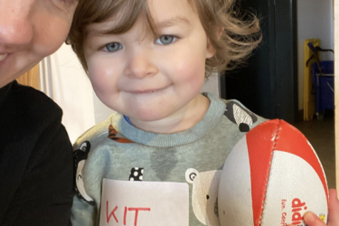 Kit Chadwick smiles holding onto a rugby ball