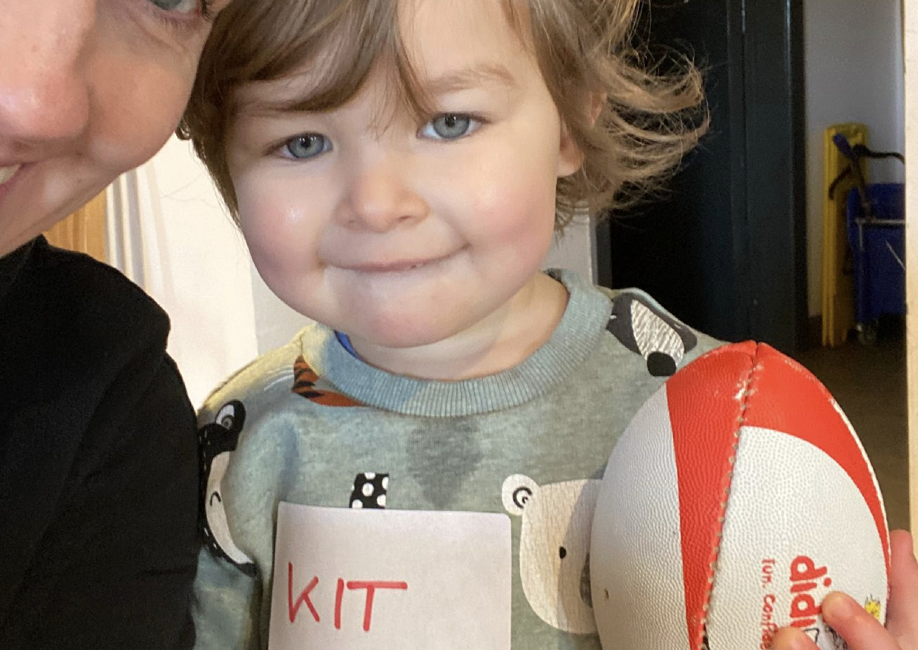 Kit Chadwick smiles holding onto a rugby ball